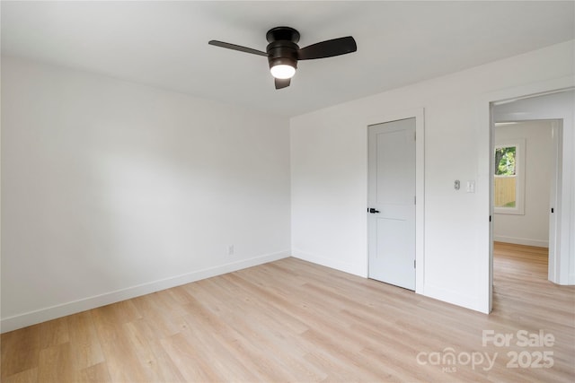 unfurnished room with light wood-style flooring, baseboards, and a ceiling fan