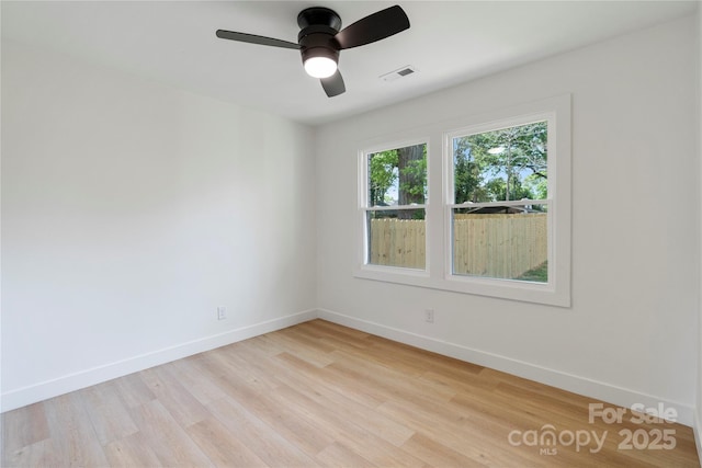 empty room with light wood-type flooring, ceiling fan, baseboards, and visible vents