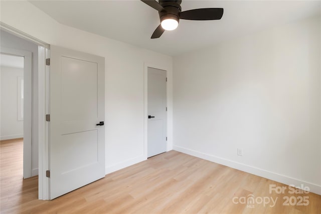 unfurnished bedroom featuring ceiling fan, light wood finished floors, and baseboards
