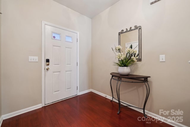 foyer entrance featuring dark wood-type flooring and baseboards