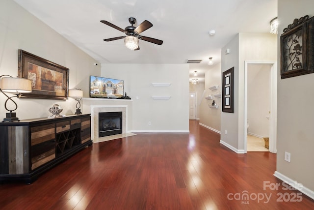 living area featuring wood-type flooring, visible vents, a fireplace, and baseboards