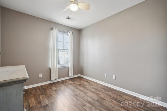 unfurnished room with a ceiling fan, wood finished floors, visible vents, and baseboards