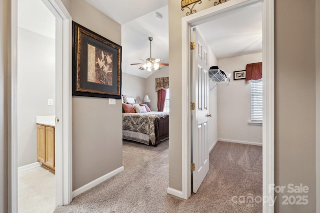 hallway with baseboards and carpet flooring