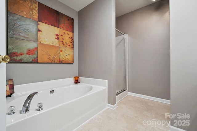 full bath featuring a shower stall, baseboards, and a bath