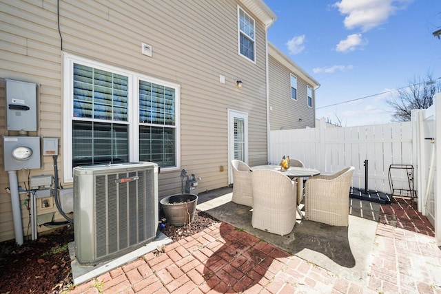 view of patio featuring outdoor dining space, central AC, and fence