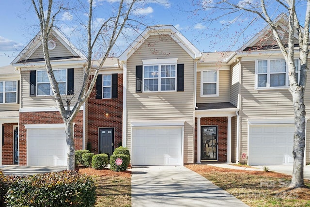 view of property with driveway, brick siding, and an attached garage