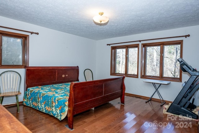 bedroom with hardwood / wood-style flooring and a textured ceiling