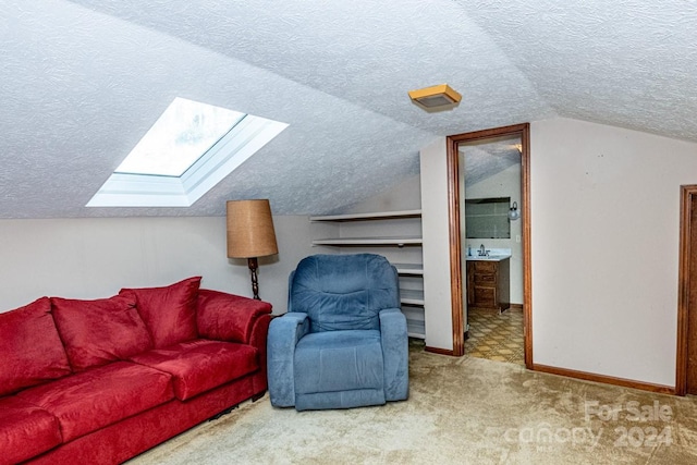 interior space with light carpet, vaulted ceiling with skylight, and a textured ceiling