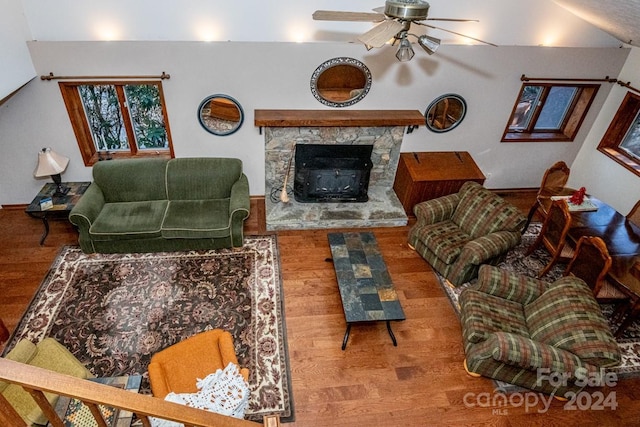 living room featuring ceiling fan, a fireplace, lofted ceiling, and hardwood / wood-style flooring