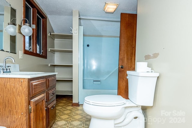 bathroom with vanity, toilet, and a textured ceiling