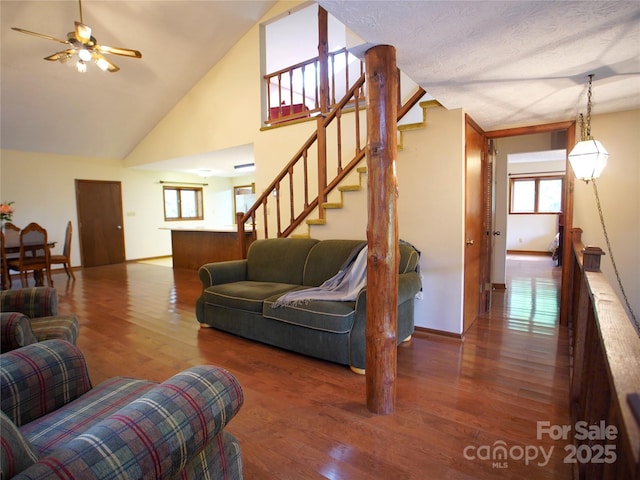 living room featuring baseboards, ceiling fan, stairs, and wood finished floors