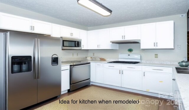 kitchen with light countertops, stainless steel appliances, white cabinetry, and under cabinet range hood