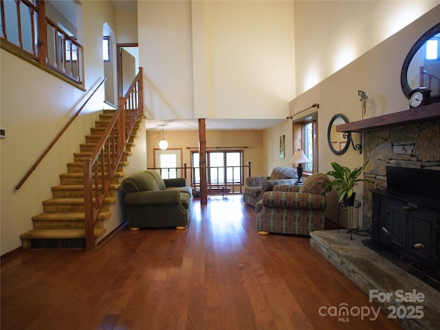living room with stairs, a high ceiling, and wood finished floors