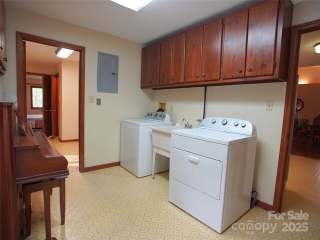 laundry room with electric panel, cabinet space, baseboards, light floors, and washer and dryer