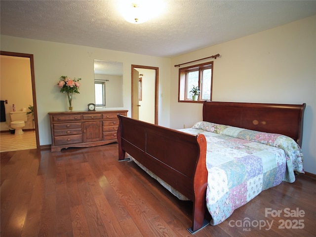 bedroom featuring a textured ceiling, dark wood-style floors, and multiple windows