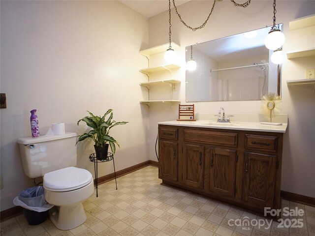 bathroom featuring a shower, tile patterned floors, baseboards, vanity, and toilet