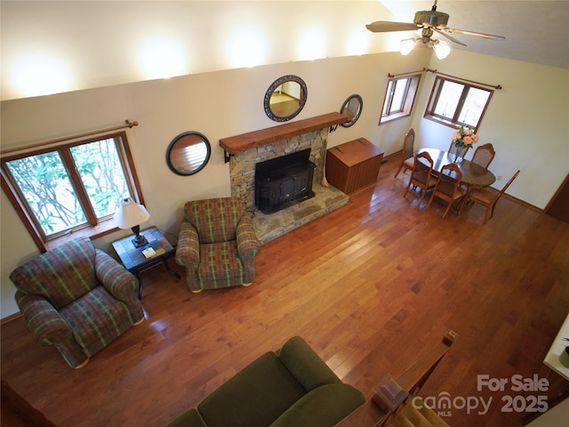 living area featuring ceiling fan, wood finished floors, and lofted ceiling