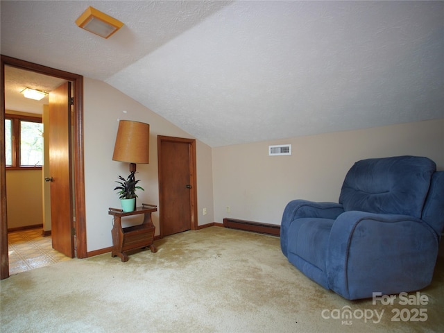 sitting room with visible vents, baseboard heating, vaulted ceiling, baseboards, and carpet flooring