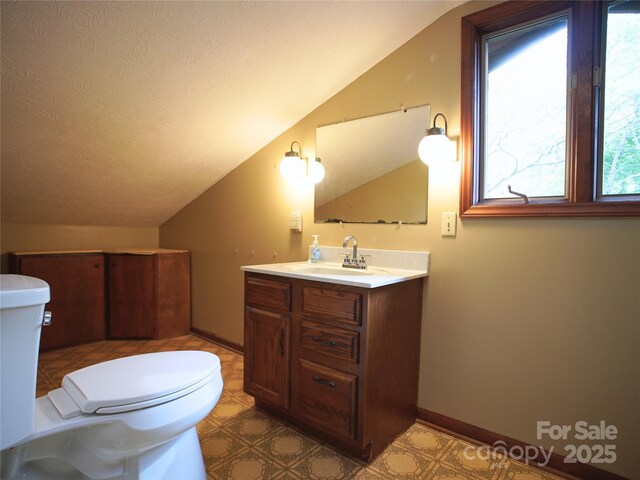 half bath featuring toilet, tile patterned floors, vaulted ceiling, and vanity
