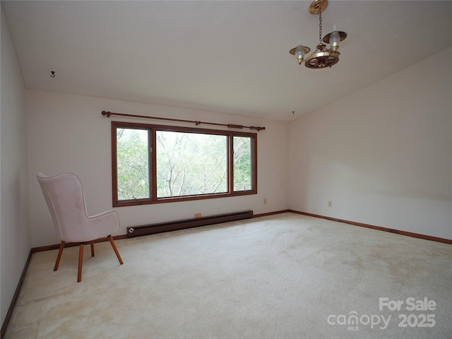 spare room with baseboards, carpet, baseboard heating, and an inviting chandelier