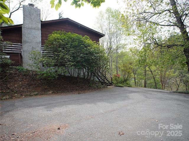 view of property exterior featuring stairs and a chimney