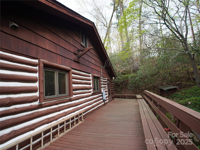 view of side of home featuring a deck and log siding