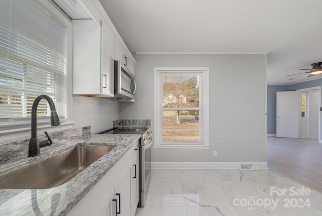 kitchen featuring white cabinets, stainless steel appliances, plenty of natural light, and sink