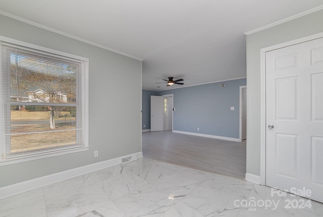 spare room featuring ceiling fan and ornamental molding