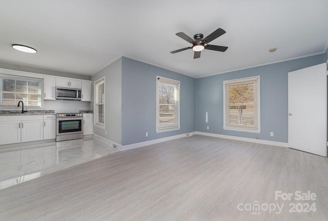 unfurnished living room featuring crown molding, ceiling fan, sink, and light hardwood / wood-style floors