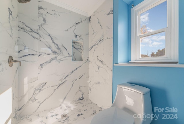 bathroom featuring crown molding, toilet, and tiled shower