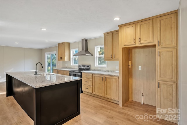 kitchen with wall chimney exhaust hood, a sink, light stone countertops, light wood-type flooring, and stainless steel electric range