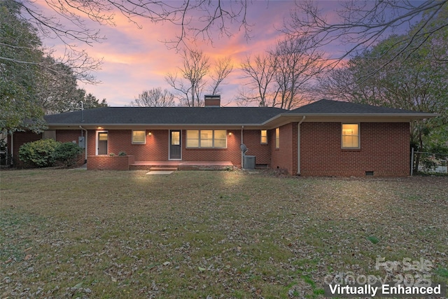 ranch-style home featuring central AC unit and a yard