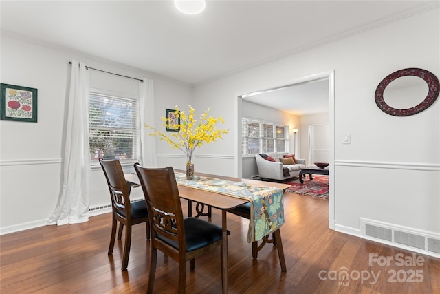 dining space with crown molding and dark hardwood / wood-style floors