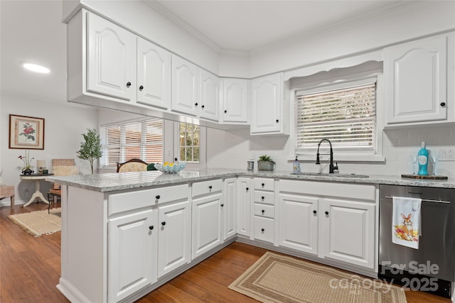 kitchen featuring hardwood / wood-style flooring, white cabinetry, light stone countertops, and sink