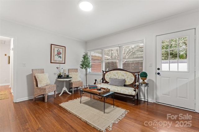 sitting room featuring ornamental molding and wood-type flooring