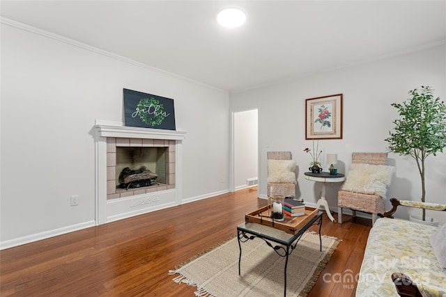 living room with crown molding, hardwood / wood-style floors, and a tile fireplace