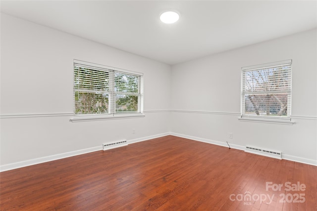 spare room featuring hardwood / wood-style flooring and a baseboard radiator