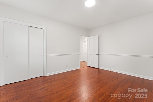 unfurnished bedroom with wood-type flooring and a closet