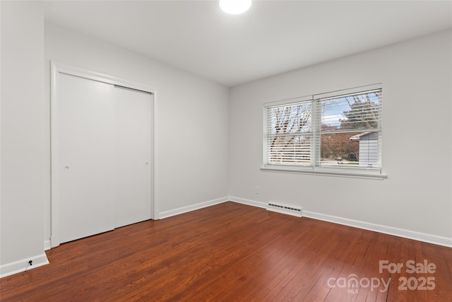 unfurnished bedroom with hardwood / wood-style flooring and a closet