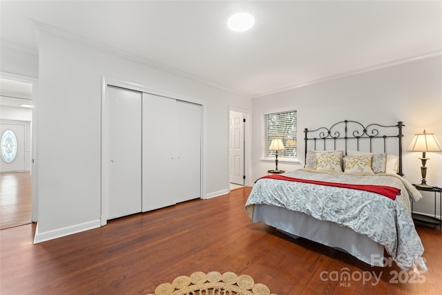 bedroom with hardwood / wood-style flooring, ornamental molding, and a closet