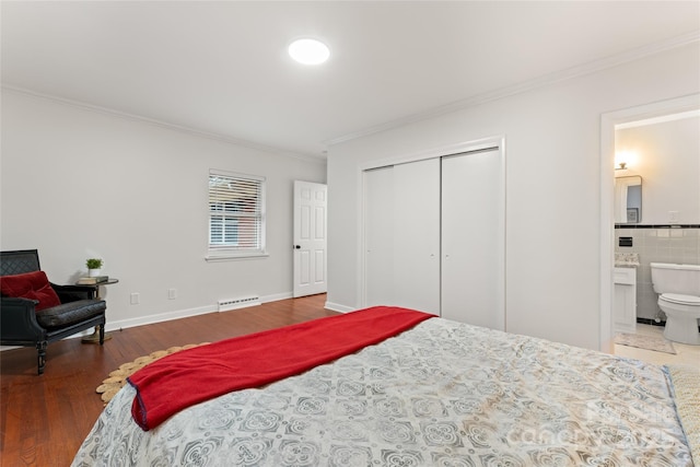 bedroom with crown molding, ensuite bathroom, a closet, and hardwood / wood-style flooring