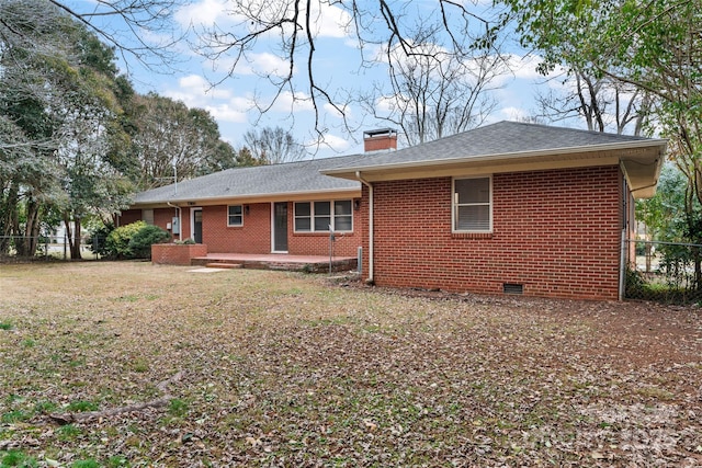 rear view of property with a patio and a lawn