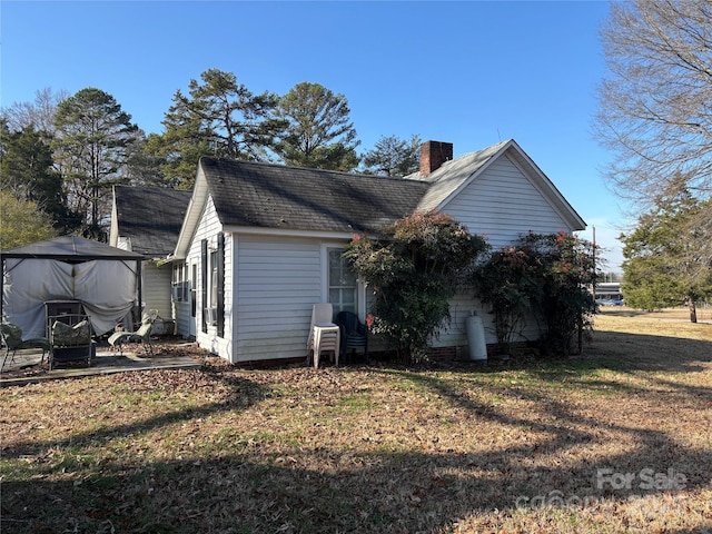 view of side of property with a lawn and a patio