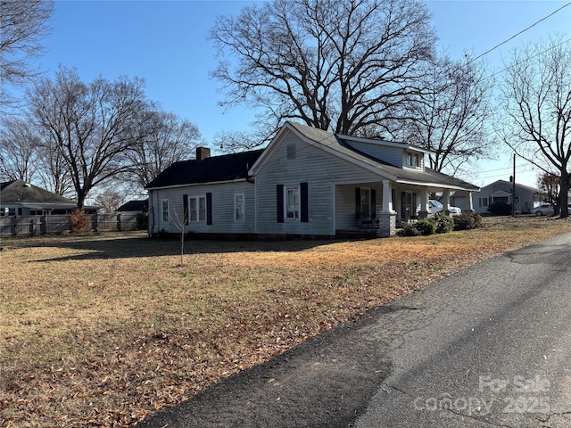 view of property exterior with covered porch and a lawn