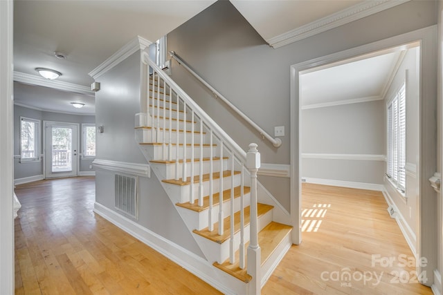 stairs with crown molding and hardwood / wood-style flooring