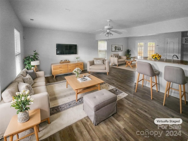 living room with dark hardwood / wood-style floors, ceiling fan, and sink