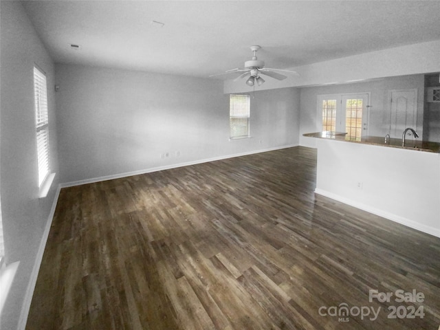 unfurnished living room with ceiling fan, dark wood-type flooring, and sink