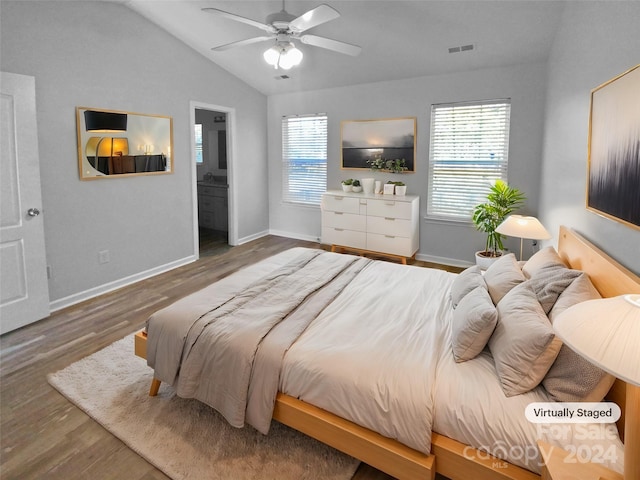 bedroom featuring ensuite bath, vaulted ceiling, dark hardwood / wood-style flooring, and multiple windows