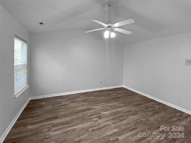 empty room with lofted ceiling, ceiling fan, and dark hardwood / wood-style floors