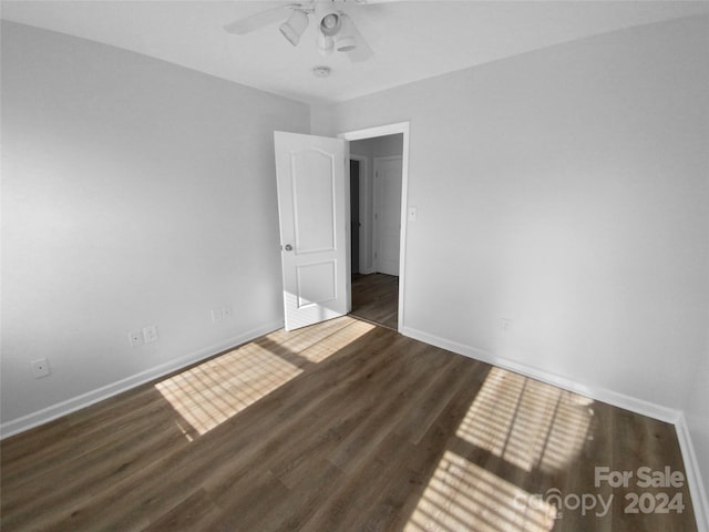 spare room with dark hardwood / wood-style floors and ceiling fan